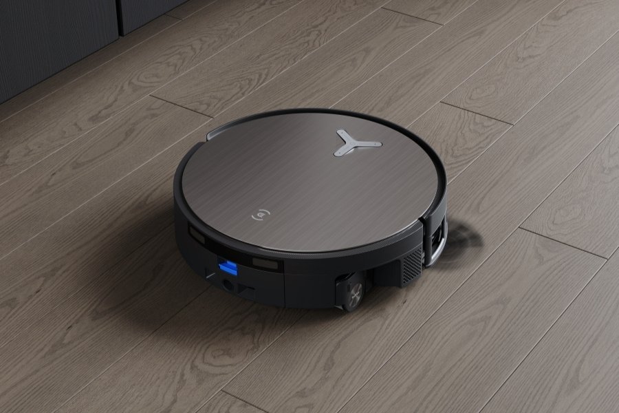 A modern robot vacuum cleaning a sunlit living room with hardwood floors.