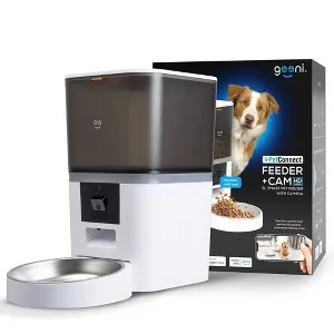 A person comparing two different automatic dog feeder models on a kitchen table.